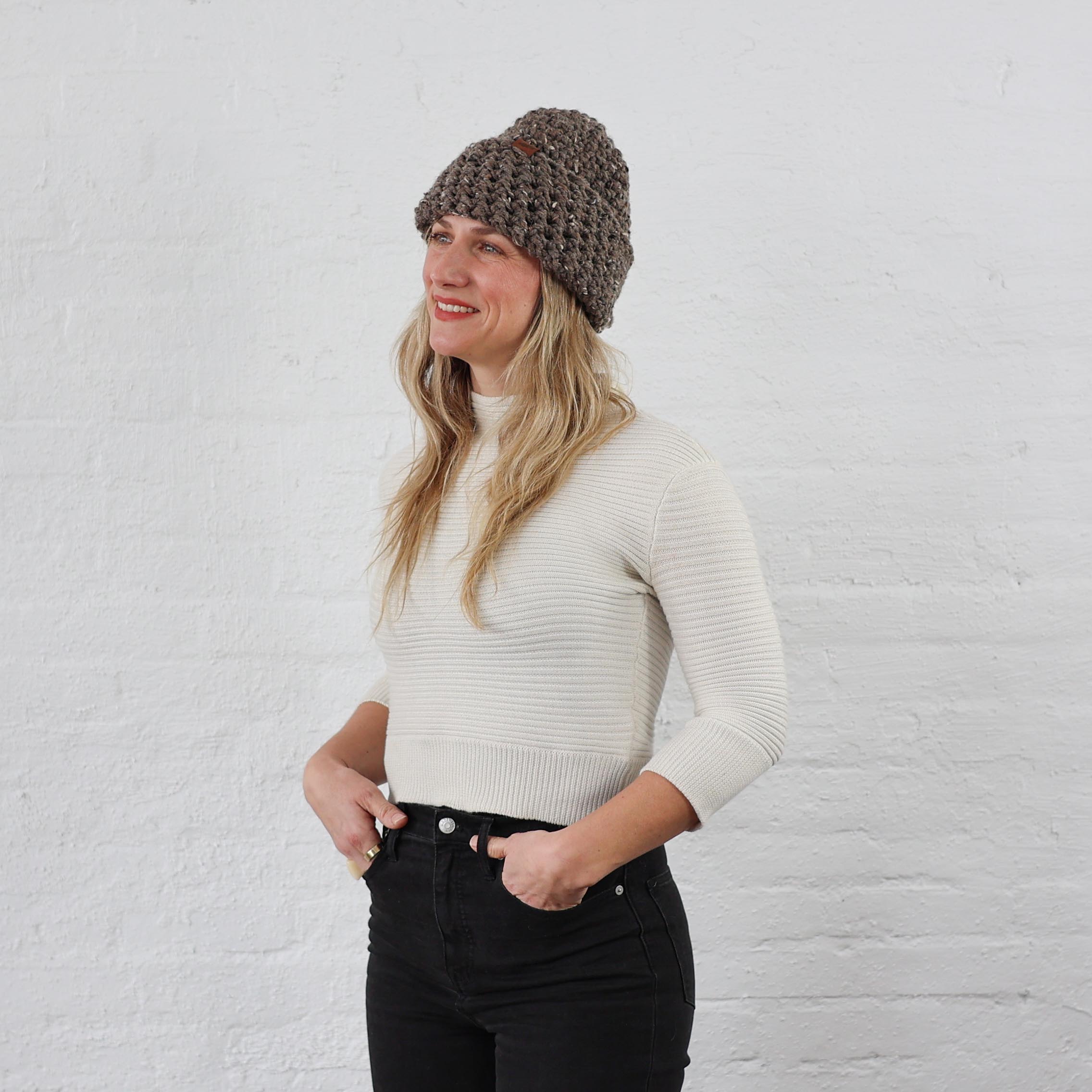 thick brown knit winter hat on woman, folded up with a cuff, has a tweed Heather effect