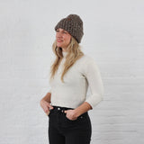 thick brown knit winter hat on woman, folded up with a cuff, has a tweed Heather effect