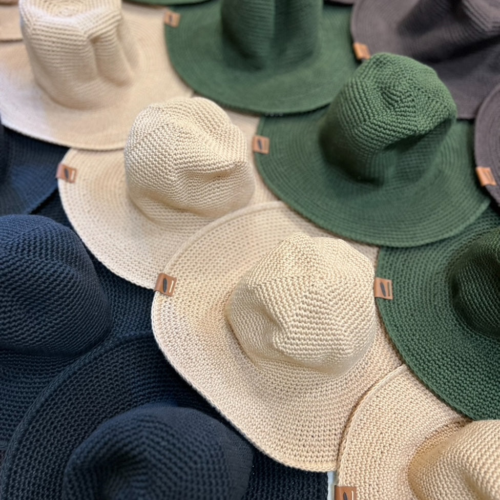 Collection of crochet cotton sun hats in various colors including beige, green, and brown and black