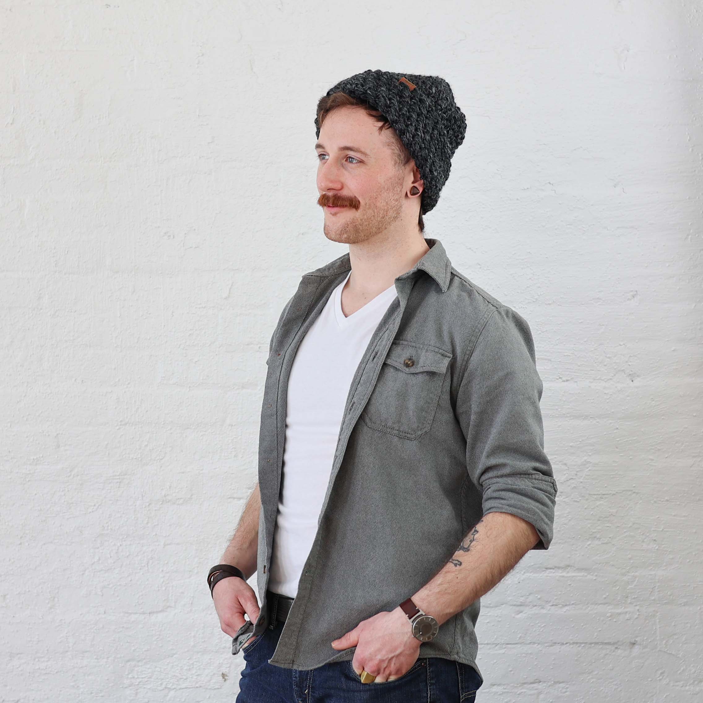 Charcoal Beanie on man that is folded up like a scullcap style, even though its a thick and tall beanie