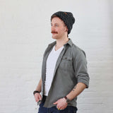 Charcoal Beanie on man that is folded up like a scullcap style, even though its a thick and tall beanie