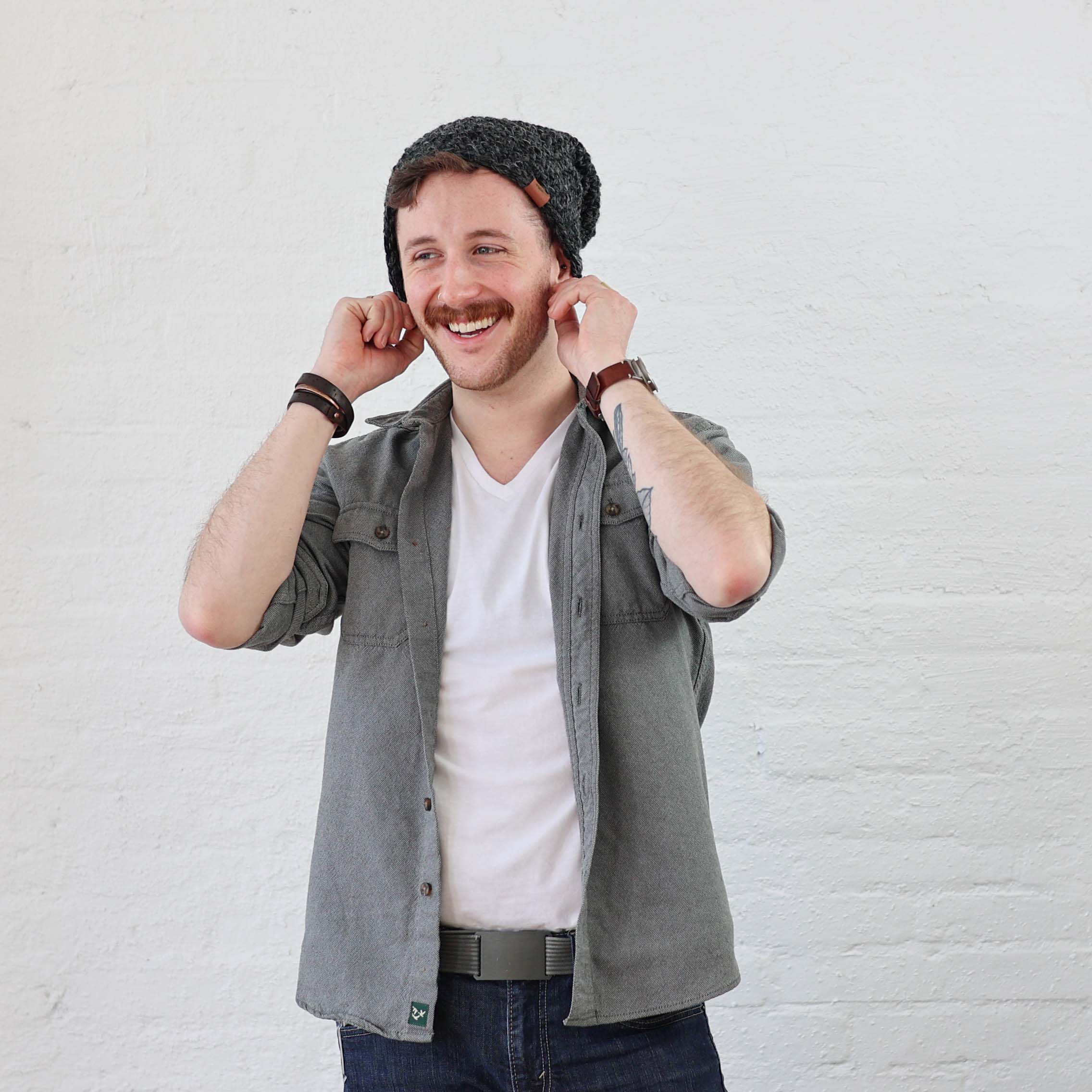 Man wearing charcoal beanie folded up with cuff. Styled casually with denim. Hat fits any size