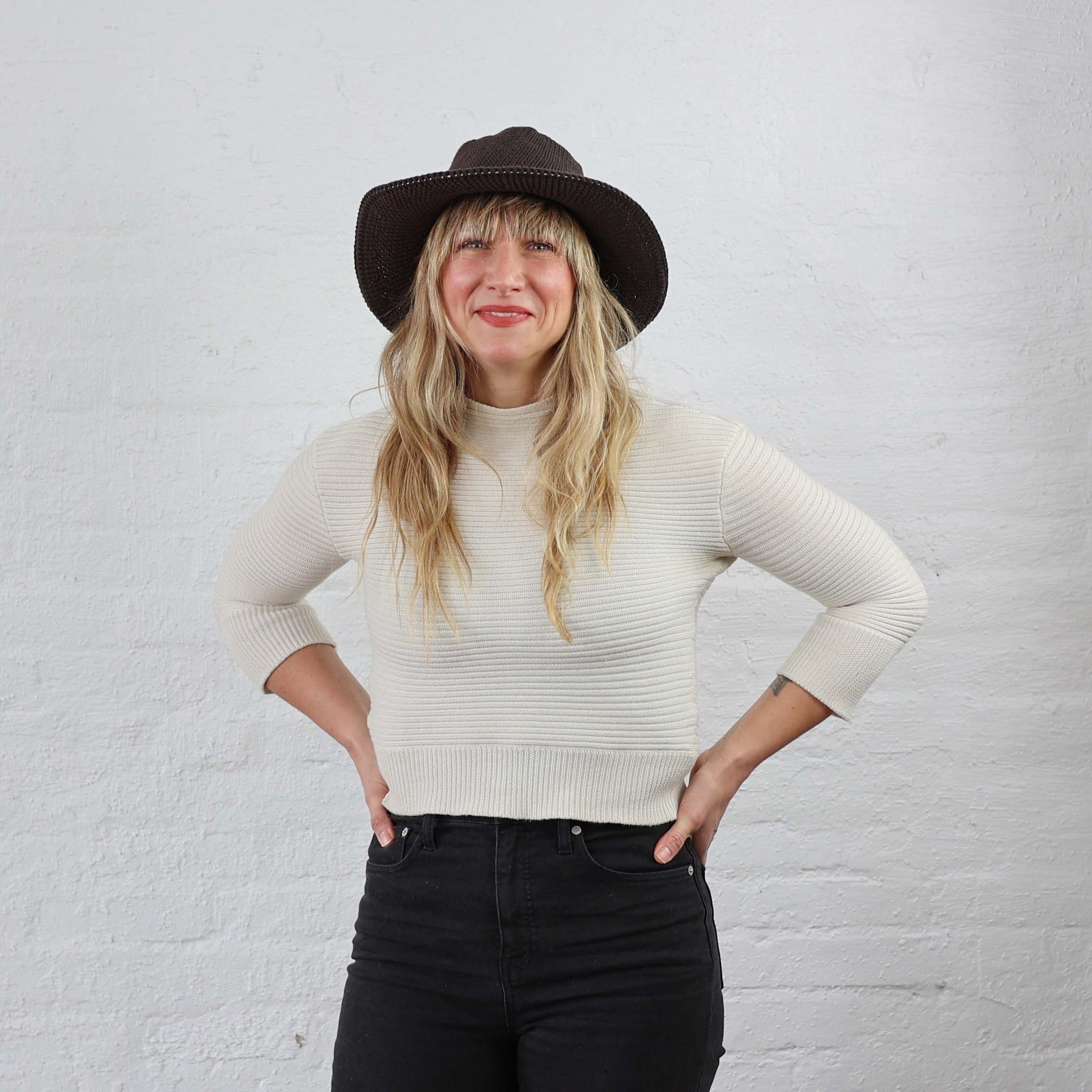 Dark espresso brown hat with floppy flexible brim, modeled on a woman. Casual everyday wear