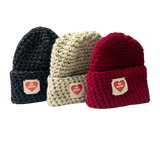 Three knit beanie hats in black, beige, and red with visible branding on a white background