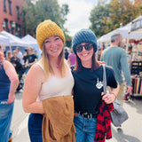 Two women wearing North Ferry Hats, these chunky knit beanies are cozy and fit all sizes