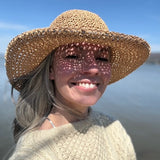 Person wearing a North ferry crochet packable straw hat with a lakefront boatyard marina background