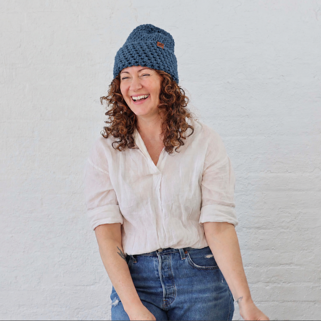 North Ferry River Blue Chunky Knit Beanie on a woman who is cozy and joyful in her hat! 