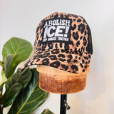 Leopard print cap with text on a mannequin head against a white background, with patch that reads ABOLISH ICE, hand-made in Ithaca NY by North Ferry Hats