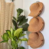 Straw hats on display in a garden center, a packable Sun hat made with natural plant based fiber, paper fiber, crochet packable Sun hats, beach hats