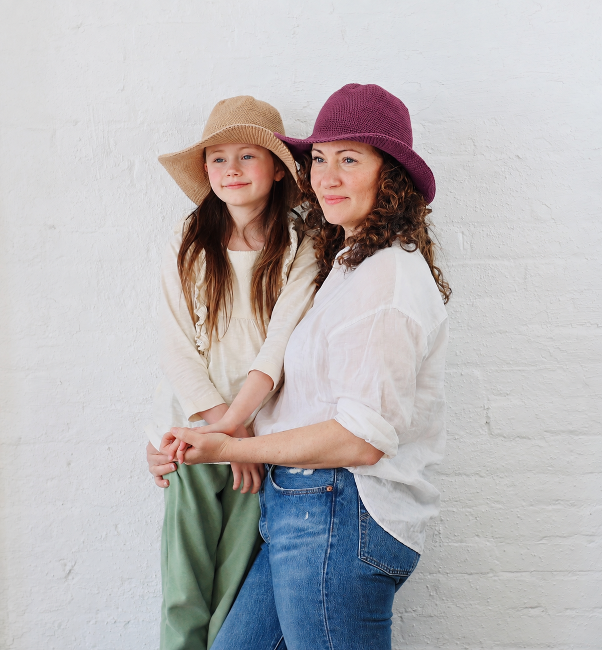 Mother and Daughter wearing matching cotton Packable Sun hats one in tan and one in purple
