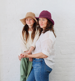 Mother and Daughter wearing matching cotton Packable Sun hats one in tan and one in purple