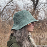 2 in 1 Bucket Hats made with Upcycled fabrics. featuring a side profile of the Teal Floral quilted fabric paired with green satin blend lining fabric