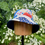 Colorful patchwork bucket hat on a mannequin head with a floral background