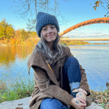 Person sitting by a lake with a scenic background