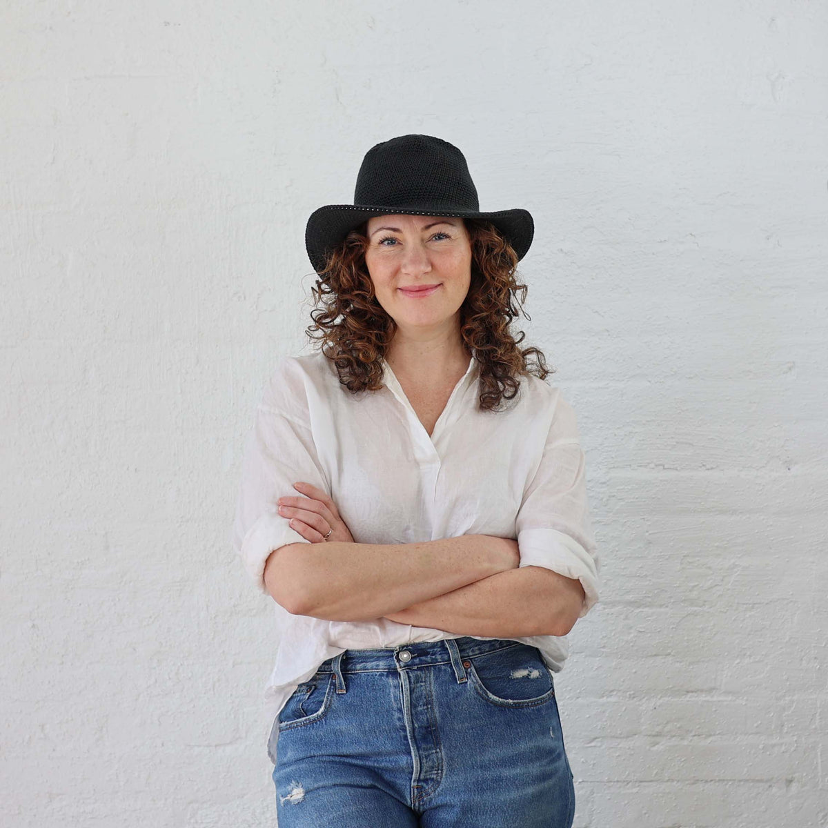 Black Crochet Sun Hat modeled on Female with curly hair.  The hat stretches to fit curly hair