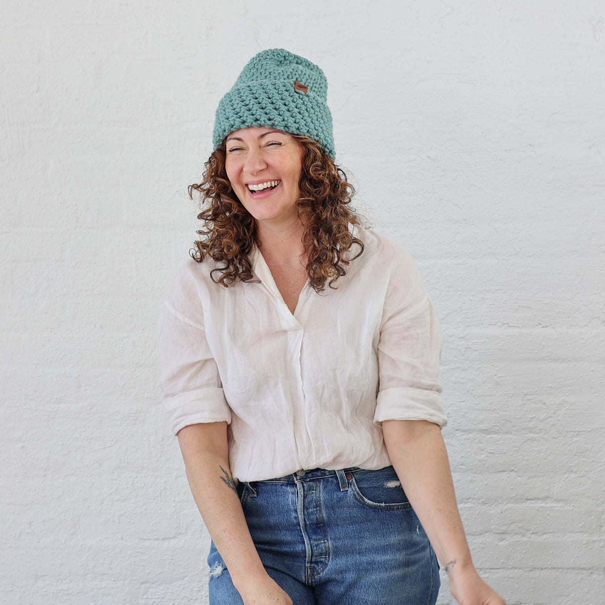 Lite Blue Thick Chunky Knit Beanie styled on a woman with curly hair, hat is folded up with thick cuff 