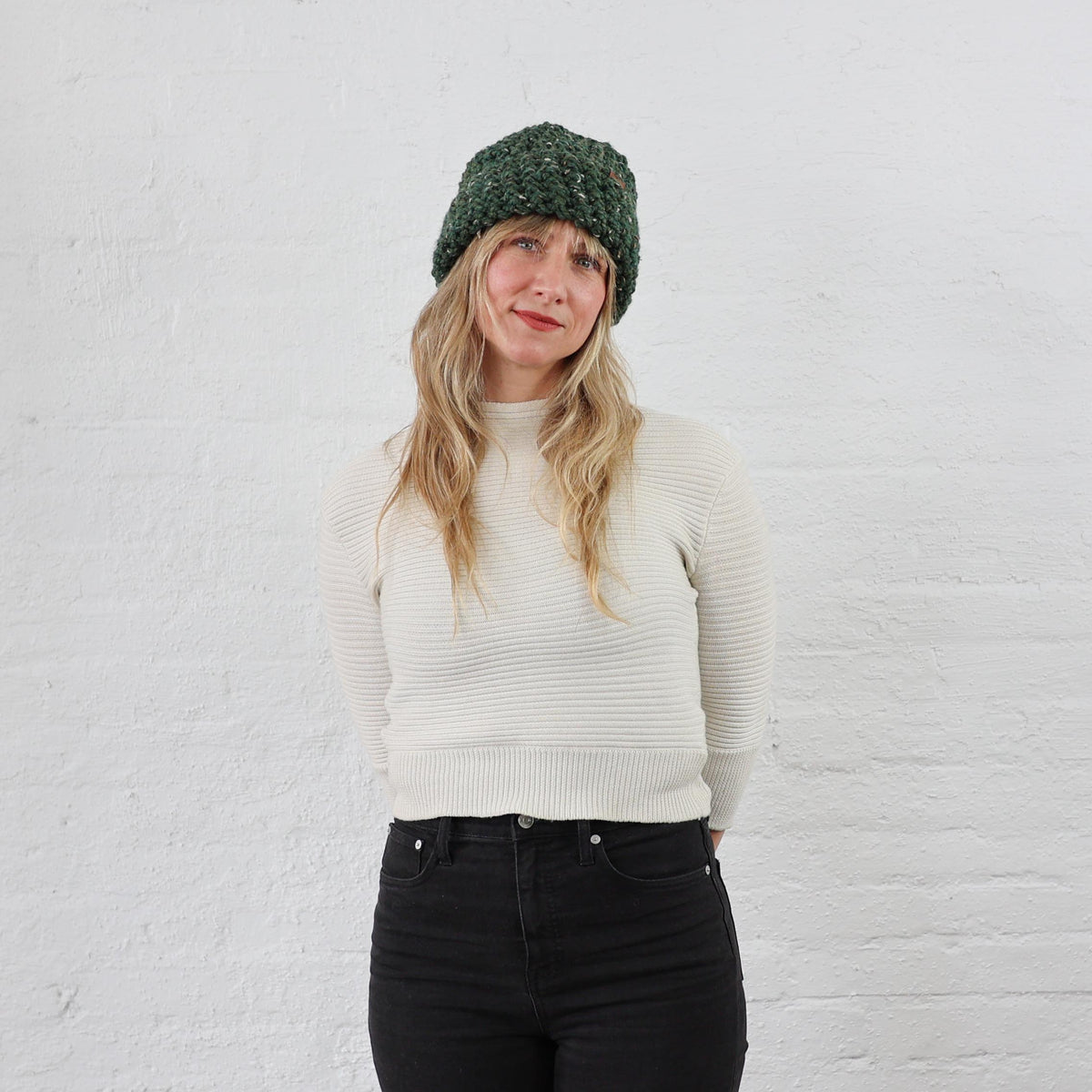Thick Green Winter Hat styled on woman, folded up with a thick wide cuff. Green Tweed speckled yarn 