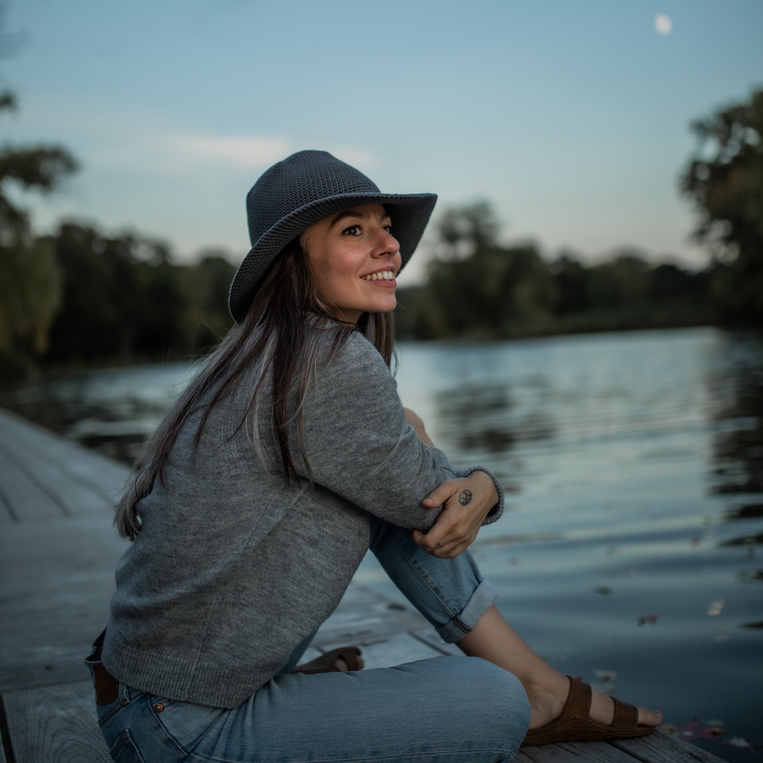 Wearing a comfortable, all-seasonal, Rain grey blue packable Sun hat during summer nights, watching the moon rise 