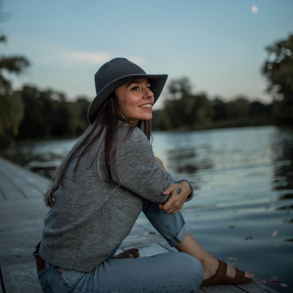 Wearing a comfortable, all-seasonal, Rain grey blue packable Sun hat during summer nights, watching the moon rise 